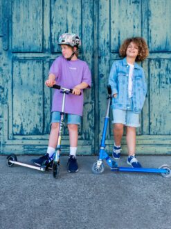 Cette image montre la trottinette Micro Sprite Néochrome lumineuse pour enfants. On y voit son design compact et pliable, son guidon réglable de 59 à 89 cm, ses roues LED à induction qui s’illuminent en roulant, ainsi que sa structure en aluminium légère et résistante. Parfaite pour les enfants dès 5 ans, elle combine fun, sécurité et confort. vendu à la maison de zazou