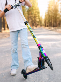 Cette image montre la trottinette Micro Sprite Néochrome lumineuse pour enfants. On y voit son design compact et pliable, son guidon réglable de 59 à 89 cm, ses roues LED à induction qui s’illuminent en roulant, ainsi que sa structure en aluminium légère et résistante. Parfaite pour les enfants dès 5 ans, elle combine fun, sécurité et confort. vendu à la maison de zazou